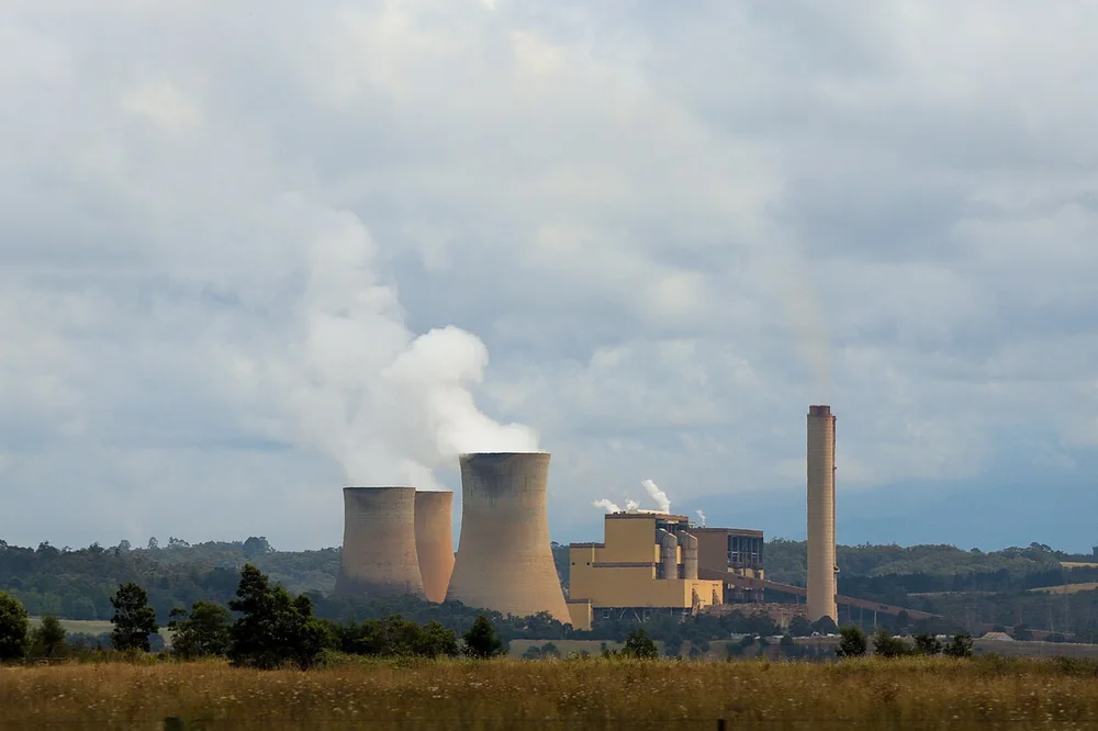 Exterior view of an entire power station with cooling towers, generating buildings and a chimney
